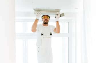un plaquiste qui pose du plâtre sur le plafond