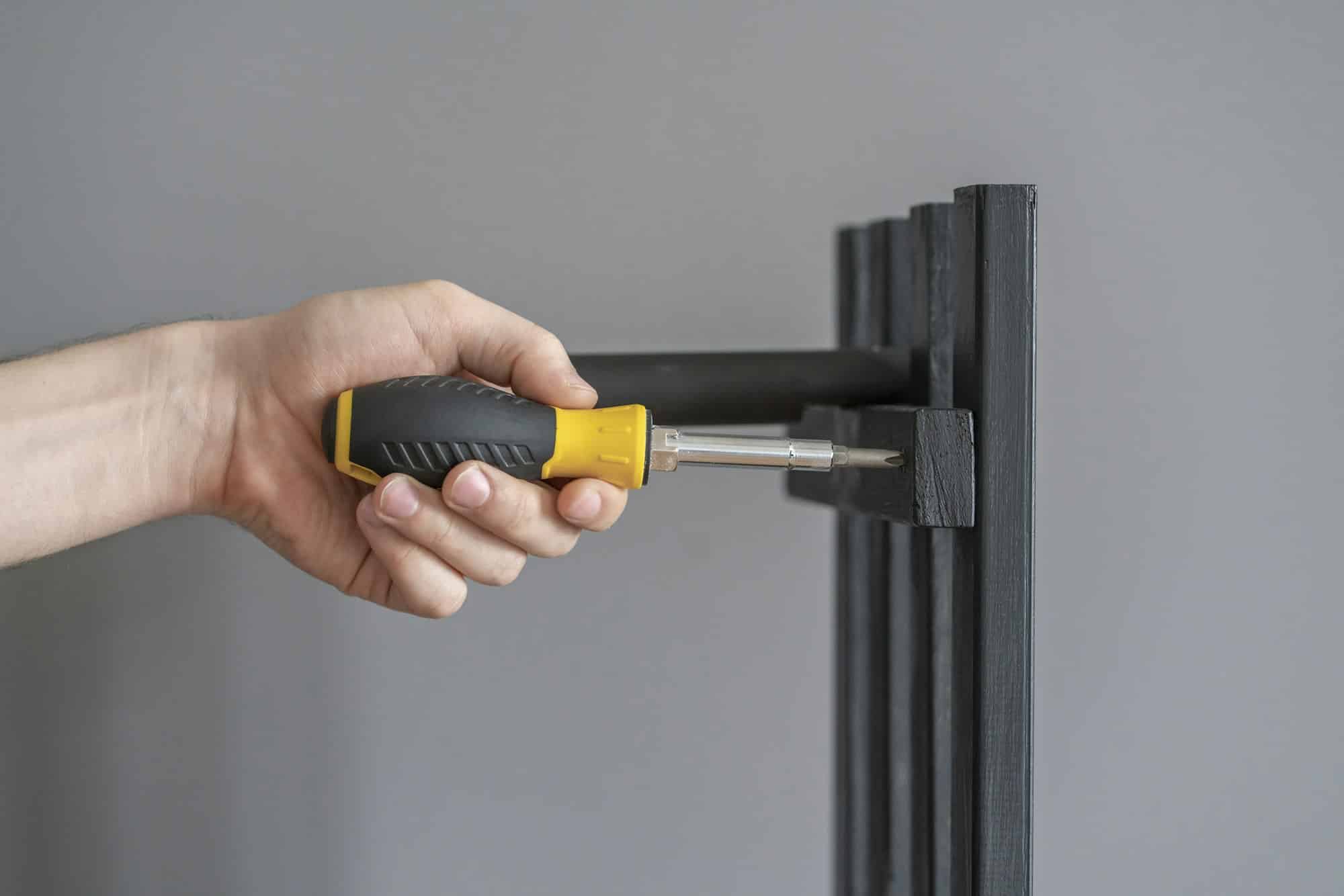 a worker hand holding a manual screwdriver tool. professional occupation work screw